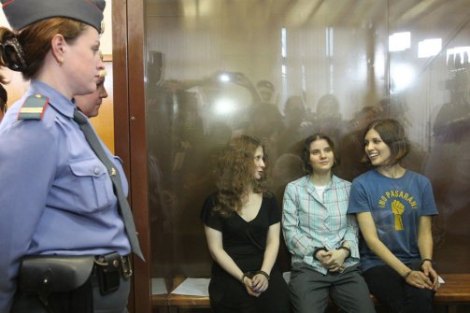 Masha, Katia, and Nadia converse with one another during a break while guards and the media look in.  (Image borrowed from http://www.thedailybeast.com/)